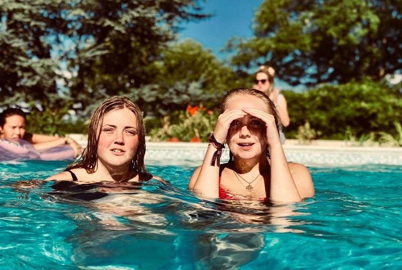 two women in swimming pool near trees 1423353